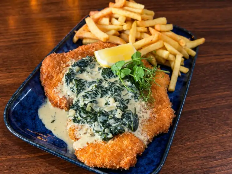 Chicken schnitzel with creamed spinach and fries at Vault Bar + Kitchen, Whalley